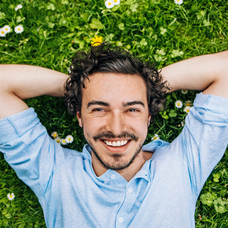 man laying in flowers smiling