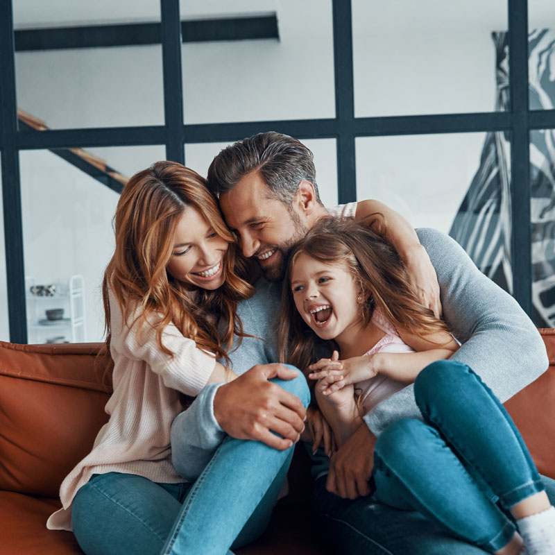 family smiling on couch